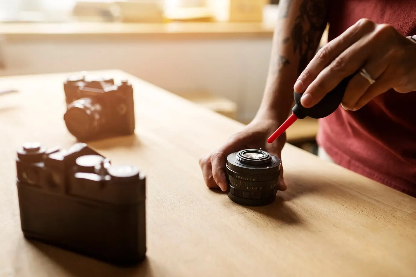 Женщина ремонтирует фотоаппарат, вид сбоку