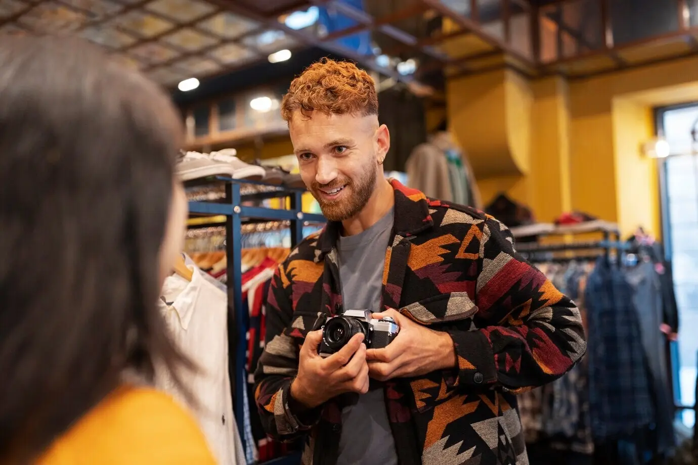 Средний план: мужчина держит старую камеру.